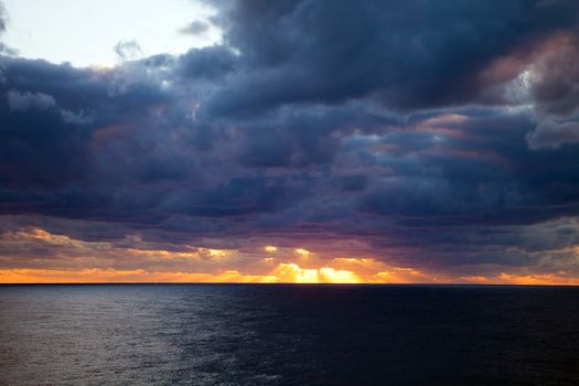 Sunset through the clouds over the Atlantic Ocean.