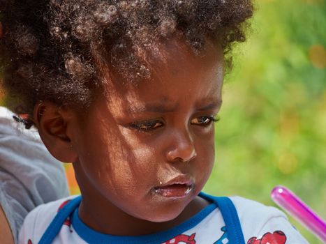 Adorable black sad baby crying with bad mood