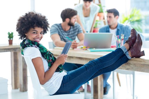 Young casual woman with feet on the table in the office