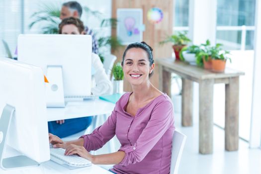 Portrait of young businesswoman using computer at office desk