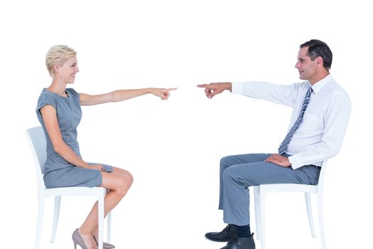 business people pointing at each other against a white wall
