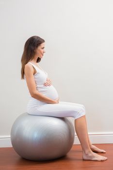 Happy pregnancy sitting on exercice ball on room 