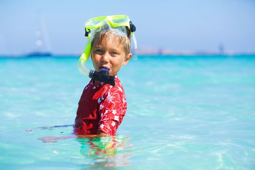 Portrait of happy cute boy wearing snorkeling mask ready to dive in the sea