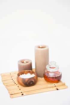 Perfumed candles and beauty products on a bamboo mat