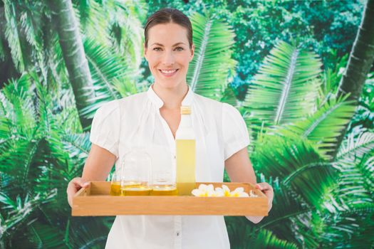 Portrait of a smiling beauty therapist holding tray of beauty treatments at the spa