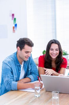 Creative business people using laptop in meeting at office