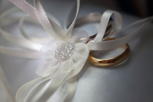Wedding rings on a white satiny fabric