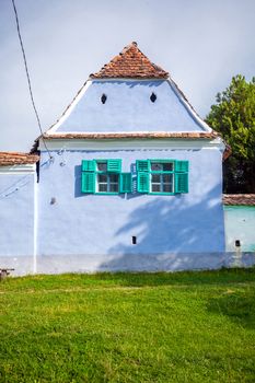 Viscri, Romania - June 23, 2013: Blue painted traditional house with green windows from Viscri village in Transylvania, Romania