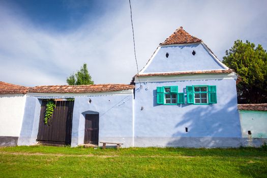 Viscri, Romania - June 23, 2013: Blue painted traditional house with green windows from Viscri village in Transylvania, Romania