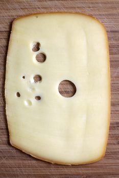 Thin plate of cheese on a wooden board