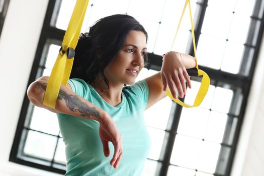 TRX. Beautiful woman at gym