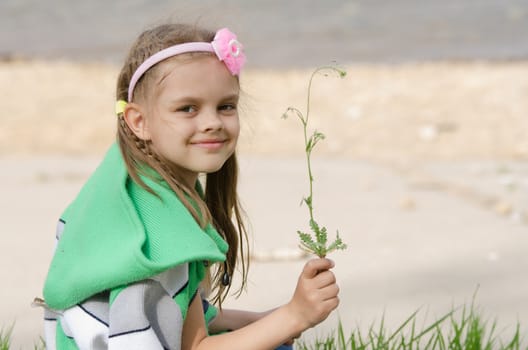 Girl happily plucked a blade of grass for a herbarium