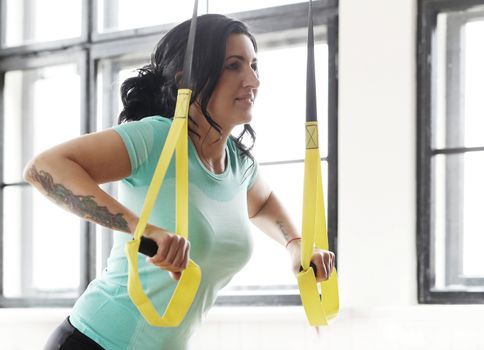 TRX. Beautiful woman at gym