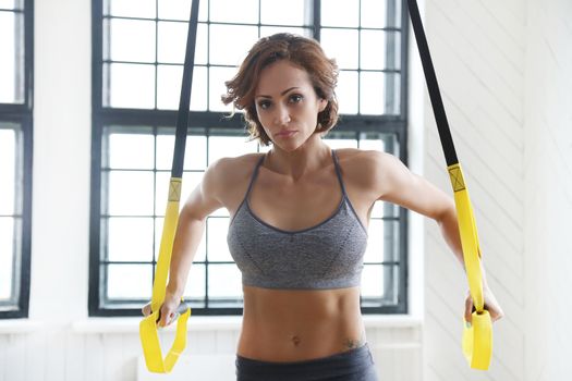 TRX. Beautiful woman at gym