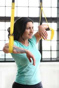 TRX. Beautiful woman at gym