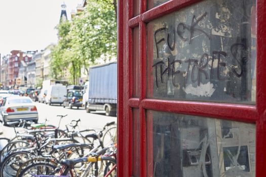 LONDON, UK - MAY 13: Detail of defaced public telephone booth with "fuck the Tories" grafitti. May 13, 2015 in London. The Conservative Party, known as Tories, won the last general elections in 2015.