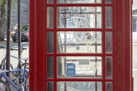 LONDON, UK - MAY 13: Detail of defaced public telephone booth with "fuck the Tories" grafitti. May 13, 2015 in London. The Conservative Party, known as Tories, won the last general elections in 2015.