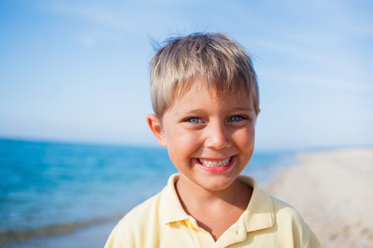 Summer vacation - Portrait of lovely boy walking on the beach near water