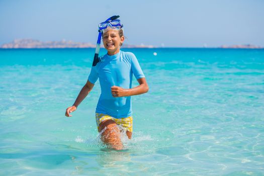 Happy cute girl wearing snorkeling mask ready to dive in the sea