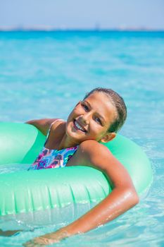 Beautiful girl relaxing on the inflatable rubber circle in the sea