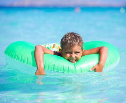 Happyboy playing on the inflatable rubber circle in the sea