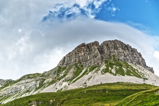 Landscape of the Mountain Castellazzo seen from Rolle Passwith clouds and blue sky background, Dolomites, Trentino - Italy