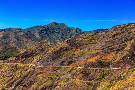 Winding or serpantine road in mountain or rock with blue sky in Tenerife Canary island, Spain at spring or summer