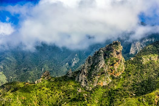 Rocks and green mountain with clouds