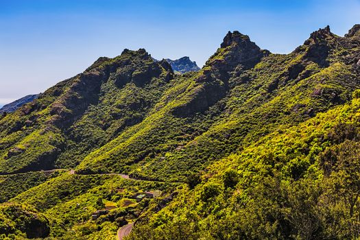 Green mountains or rocks valley with winding or serpantine road and sky nature landscape in Tenerife Canary island, Spain at summer or spring
