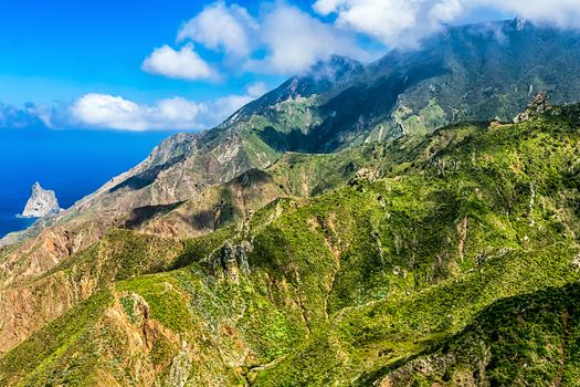 Clouds and green mountains or rocks  near the Atlantic ocean landscape in Tenerife Canary island, Spain