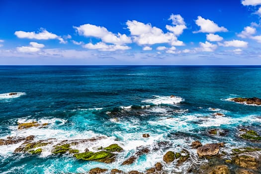 Stone shore of Atlantic ocean and sky with clouds and skyline or horizon landscape in Tenerife Canary island, Spain at spring or summer