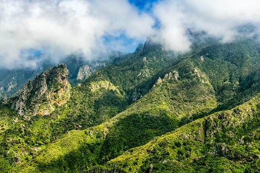 Green mountain and rocks with clouds