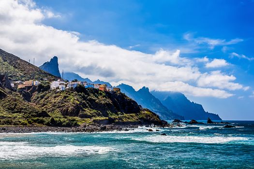 Coast or shore of Atlantic ocean with green mountain or rock and  sky with clouds and skyline in Tenerife Canary island, Spain at spring or summer