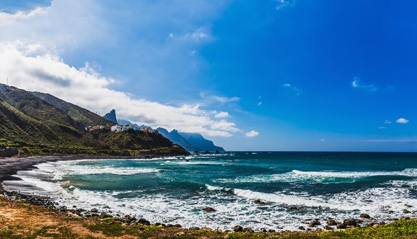 Coast or shore of Atlantic ocean with  mountain or rock and blue sky with clouds and skyline or horizon in Tenerife Canary island, Spain at spring or summer