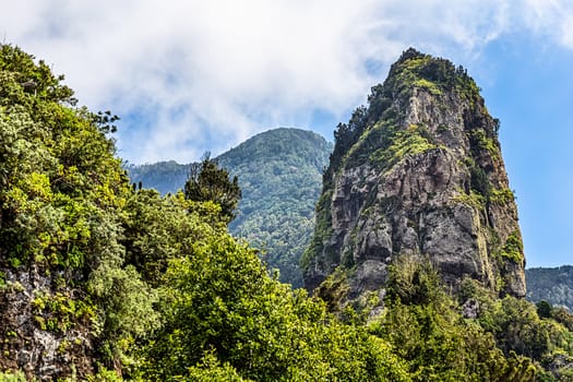 Rocks in green mountain with clouds in sky. Tenerife Canary island, Spain