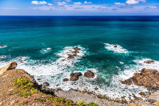 Stone coast or shore of ocean with waves and sky with clouds and skyline or horizon landscape in Tenerife Canary island, Spain