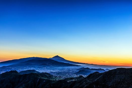 Sunset in mountains and blue sky with fog and Teide volcano on background in Tenerife Canary island, Spain at spring or summer
