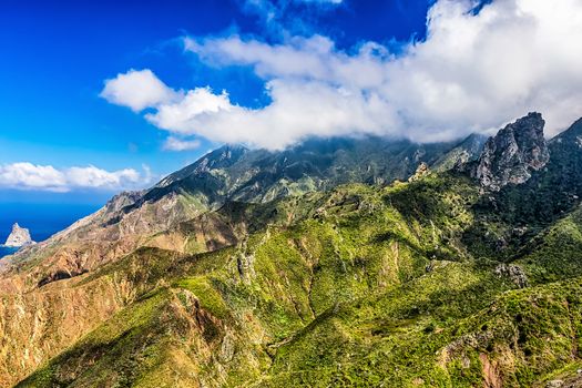 Green mountains with clouds on blue sky landscape in Tenerife island, Spain