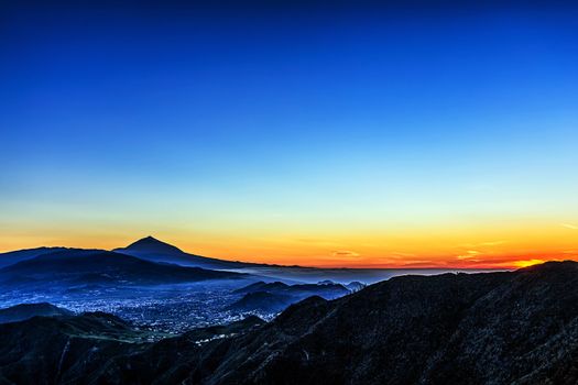 Sunset in mountains and blue sky with fog and Teide volcano on background in Tenerife Canary island, Spain