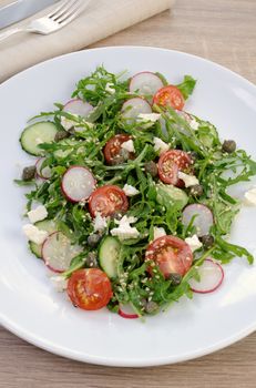 Vegetable salad with arugula, feta ,olive dressing and  sesame seeds