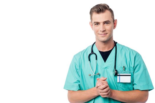 Young doctor posing over white, hands clasped.