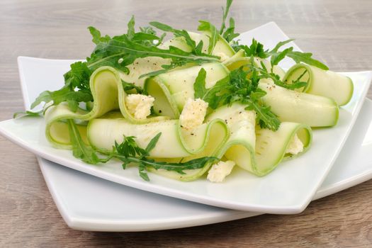 Salad from zucchini ribbon with arugula and feta