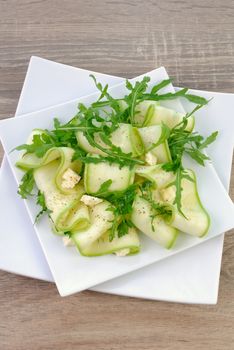 Salad from zucchini ribbon with arugula and feta