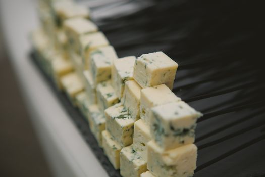 Various types of cheese on the black board. Shallow dof
