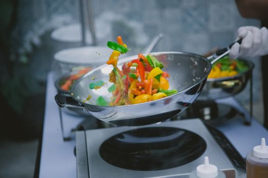 Chef cooking vegetables in wok pan. Shallow dof