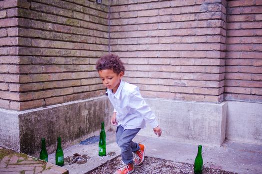 VENICE, ITALY - MAY 06: Child in the street playing with beer bottles on May 06, 2015