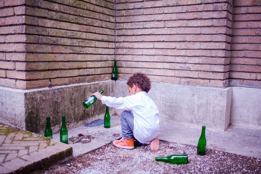 VENICE, ITALY - MAY 06: Child in the street playing with beer bottles on May 06, 2015
