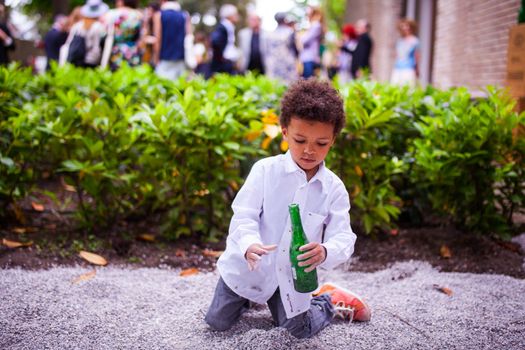 VENICE, ITALY - MAY 06: Child in the street playing with beer bottles on May 06, 2015