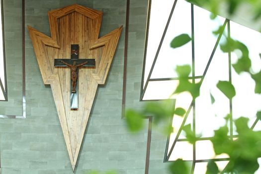 Cross on wooden wall background in church