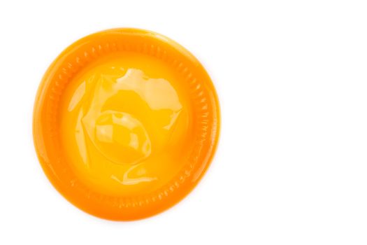 orange condom on white background from topview